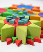 A close up, side view of the triangular shaped blocks from the Grimm's Octagon Puzzles used to created flower shapes withe the large set used for the flowers and the smaller sets used for the stems and details.