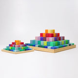 The large Grimm's rainbow coloured Large Stepped Pyramid wooden toy building block set pictured next to a small version. These Grimm's toys are part of a wide range of wooden toys available here at Babipur.
