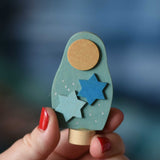 A Grimm's Matryoshka Stars Decorative Figure shown in an adult's had for scale.