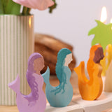 A close up of the purple, blue and orange mermaid wooden decorative figures slotted in the celebration ring