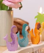 A close up of the purple, blue and orange mermaid wooden decorative figures slotted in the celebration ring