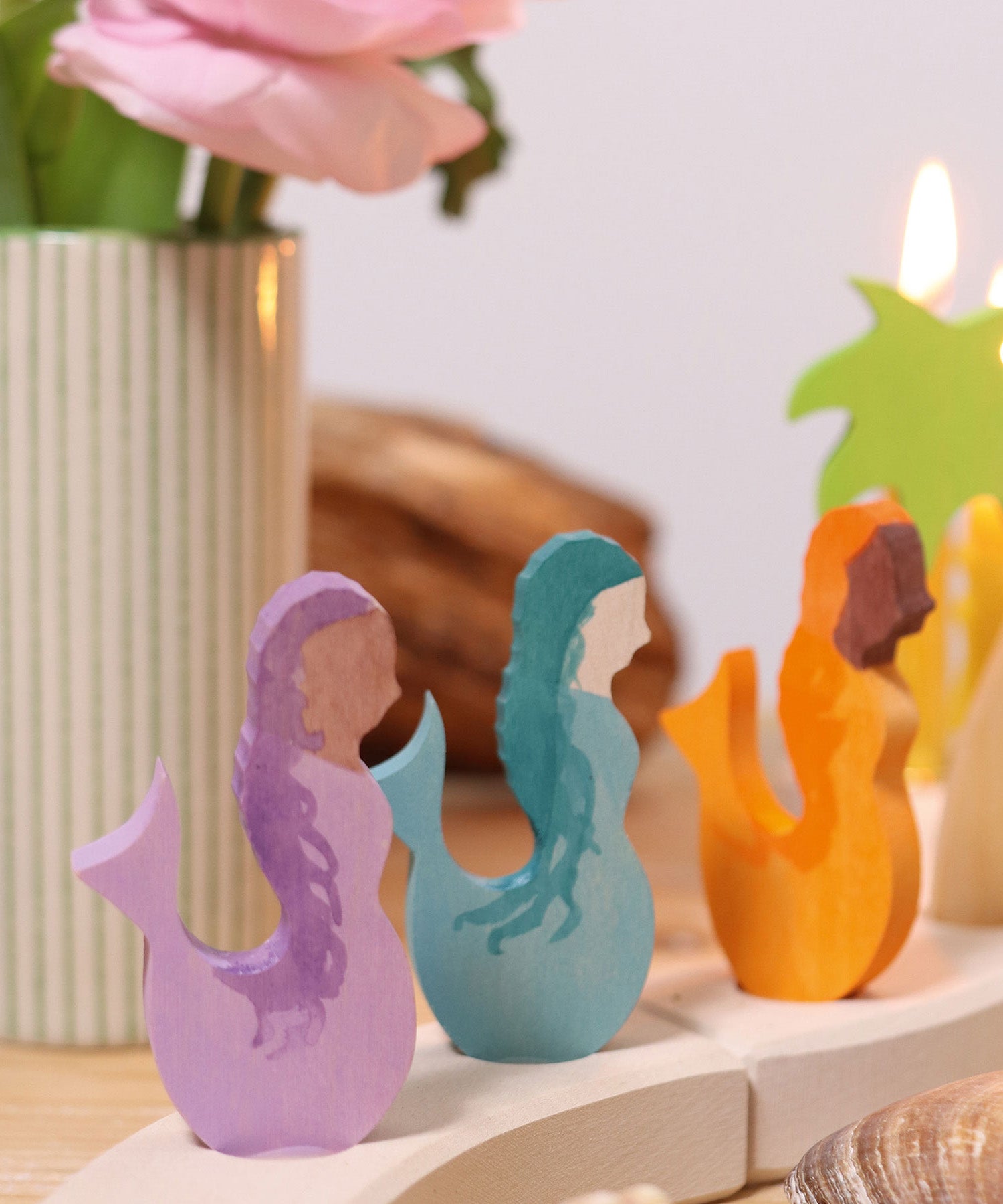 A close up of the purple, blue and orange mermaid wooden decorative figures slotted in the celebration ring
