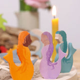 A close up of the purple, blue and orange mermaid wooden Grimms decorative figures slotted in the celebration ring showing the hand painted detail