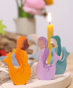 A close up of the purple, blue and orange mermaid wooden Grimms decorative figures slotted in the celebration ring showing the hand painted detail