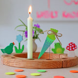 Grimm's Sweet Cone Decorative Figure - Neon Green. The cone sits inside the Celebration ring alongside other figures and a candle.