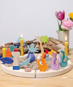 A ocean themed setup featuring different wooden Grimms figures including the mermaids slotted on a celebration ring