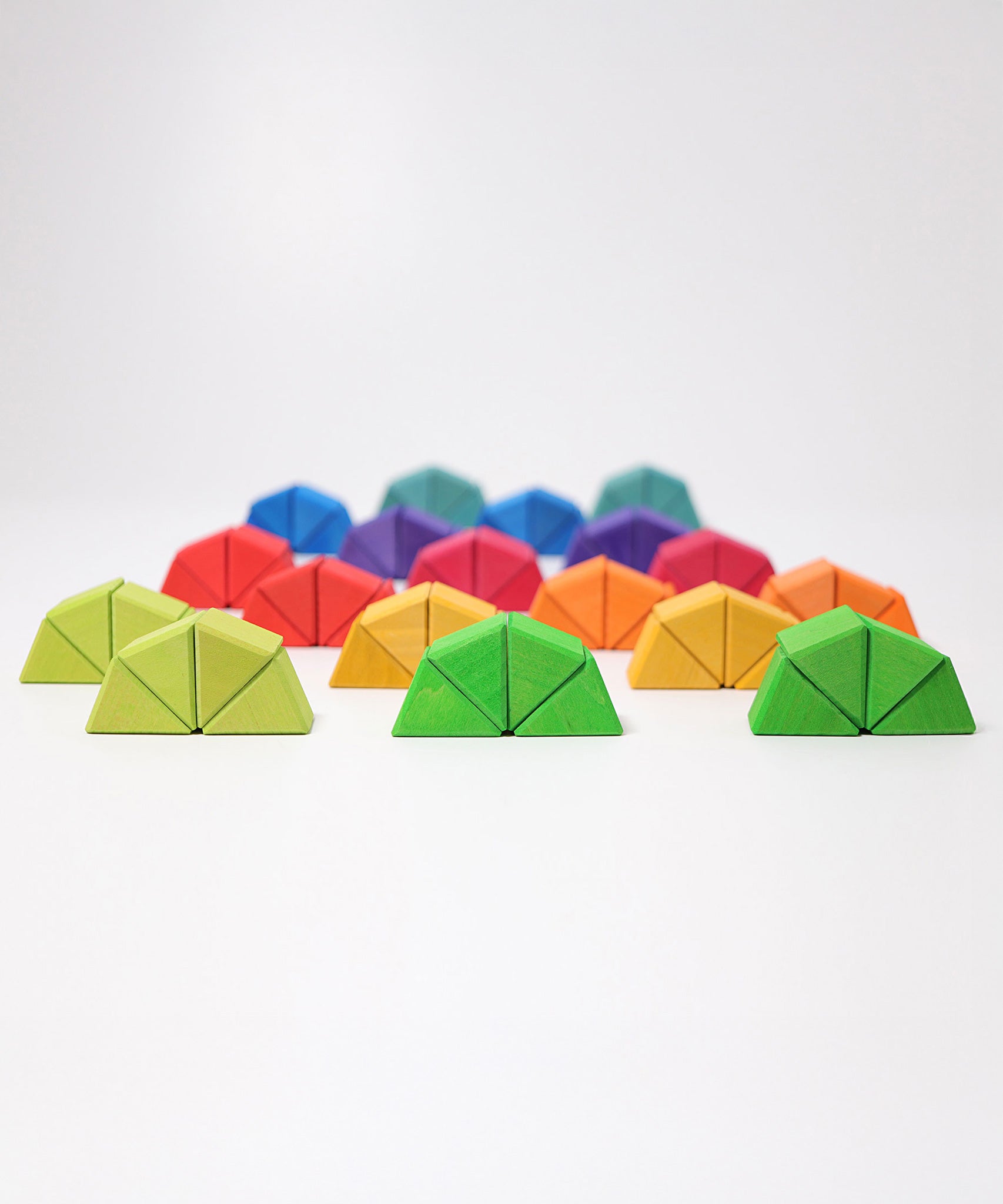The triangluar shaped blocks from the Grimm's Octagon Puzzles shown stacked together in groups of 4 to create semi circles.