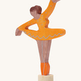 A Grimms wooden ballerina decorative figure in orange. Features a small base on the bottom to slot into the celebration ring.