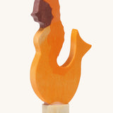 A Grimms wooden mermaid decorative figure in orange. Features a small base stand to slot in the celebration ring