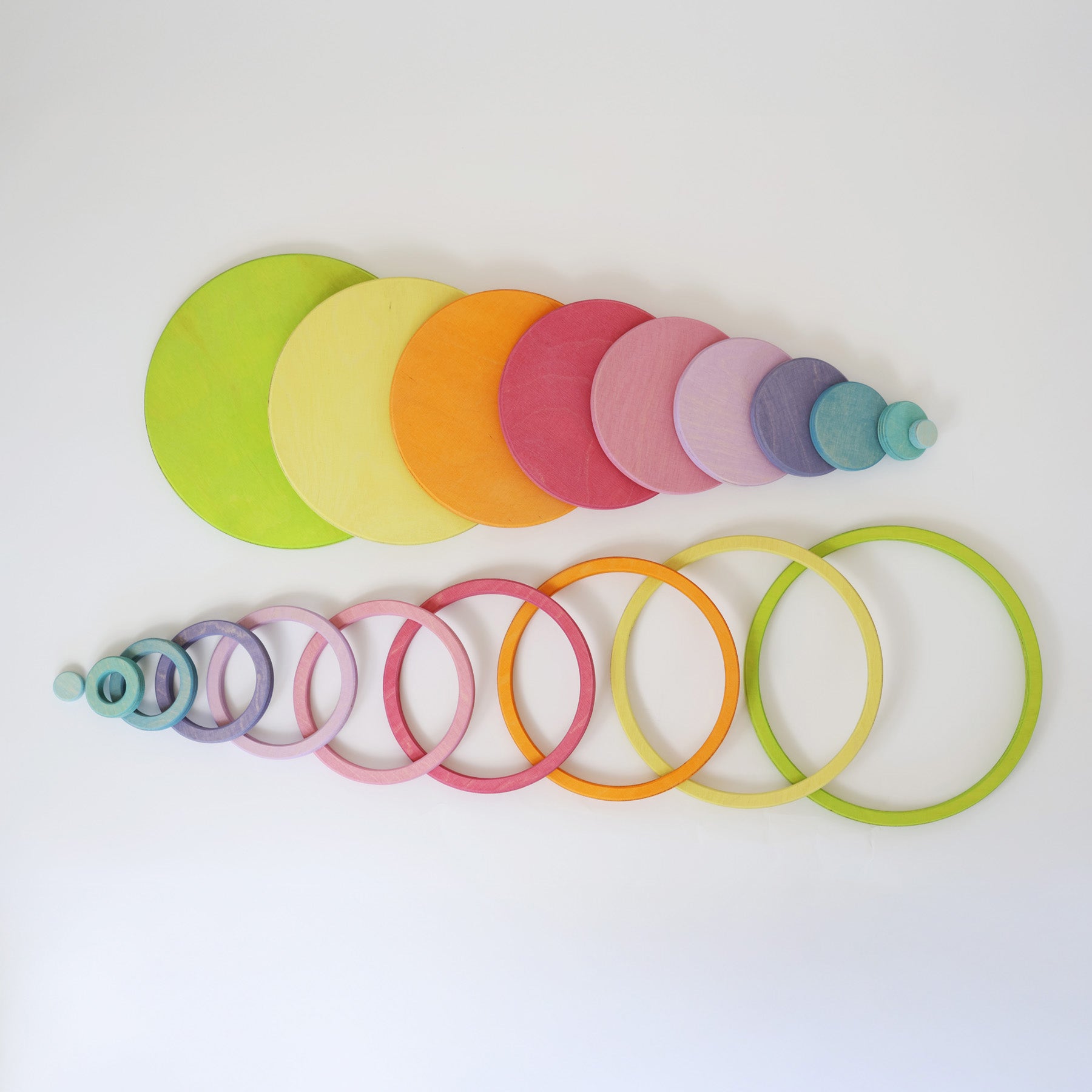 Grimm's pastel rainbow wooden concentric circles and rings arranged by size and colour, perfect for stacking, nesting, sorting, and open-ended play. Ideal Montessori and Waldorf-inspired educational toy.