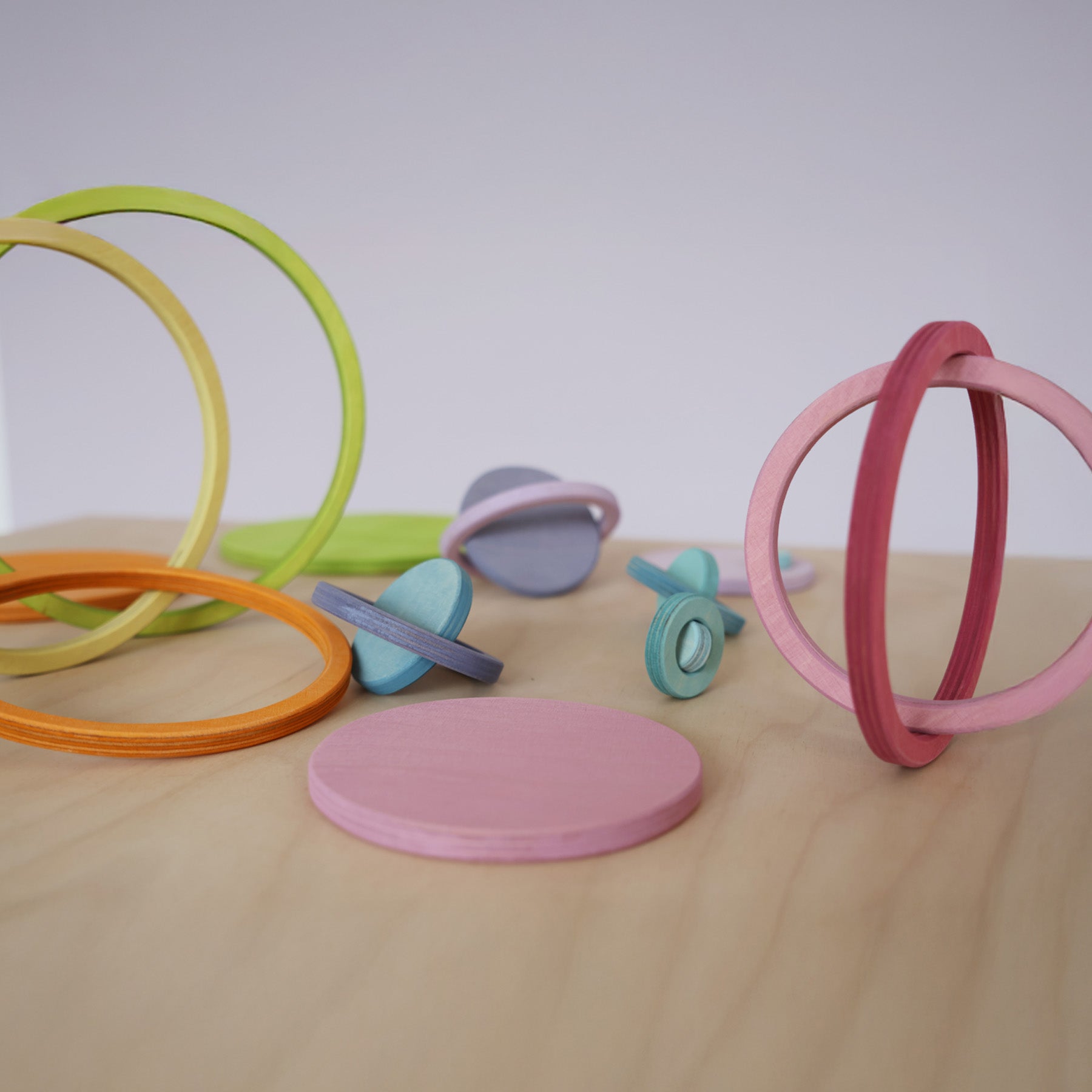 Creative builds using Grimm's concentric rings balanced together, ideal for imaginative open-ended play and motor skill development.