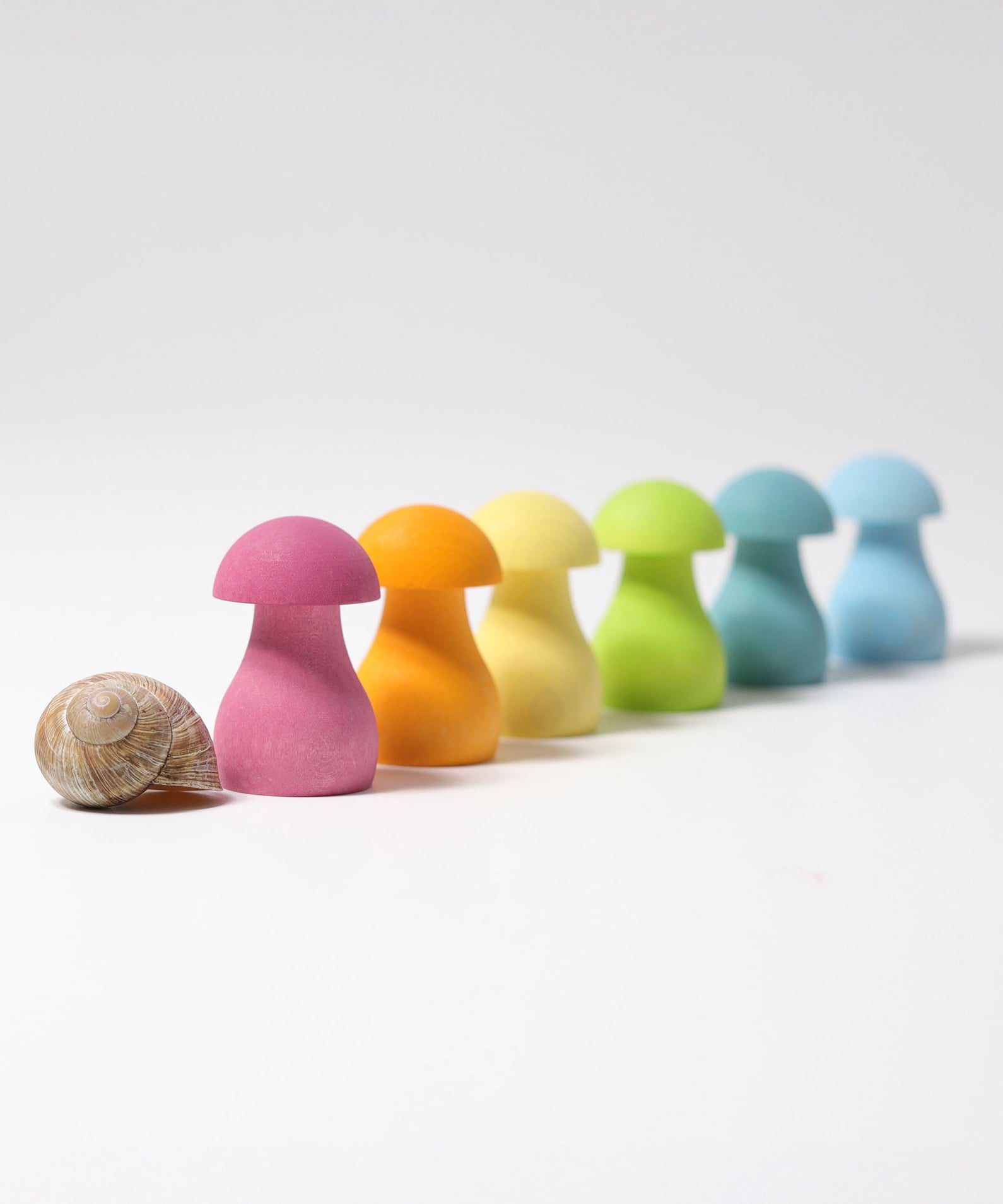 Grimm's Pastel Mushrooms Sorting Game shown all lined up next to a snail shell.