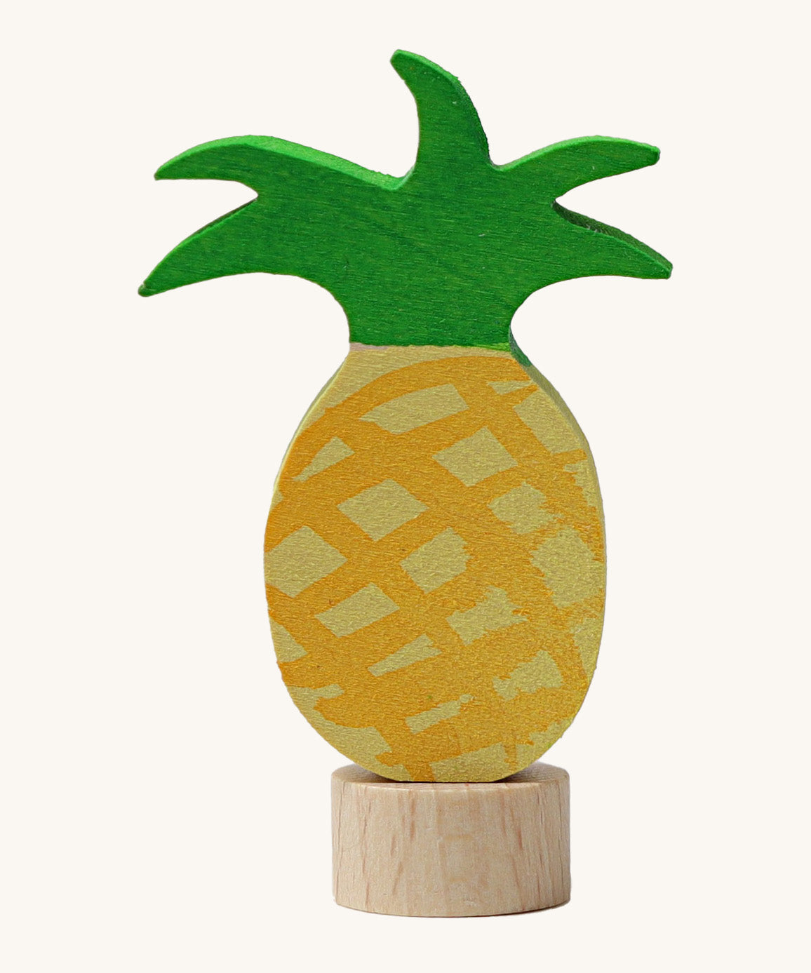 A Grimms pineapple wooden decorative figure with green leaves and a small base stand to slot into a decorative ring