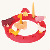 Grimm's Red 12-Hole Celebration Ring with decorative figures on a plain background.