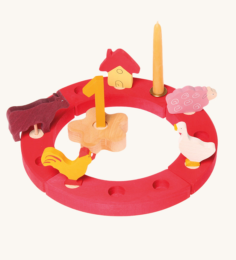 Grimm's Red 12-Hole Celebration Ring with decorative figures on a plain background.