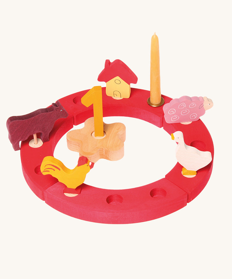 Grimm's Red 12-Hole Celebration Ring with decorative figures on a plain background.