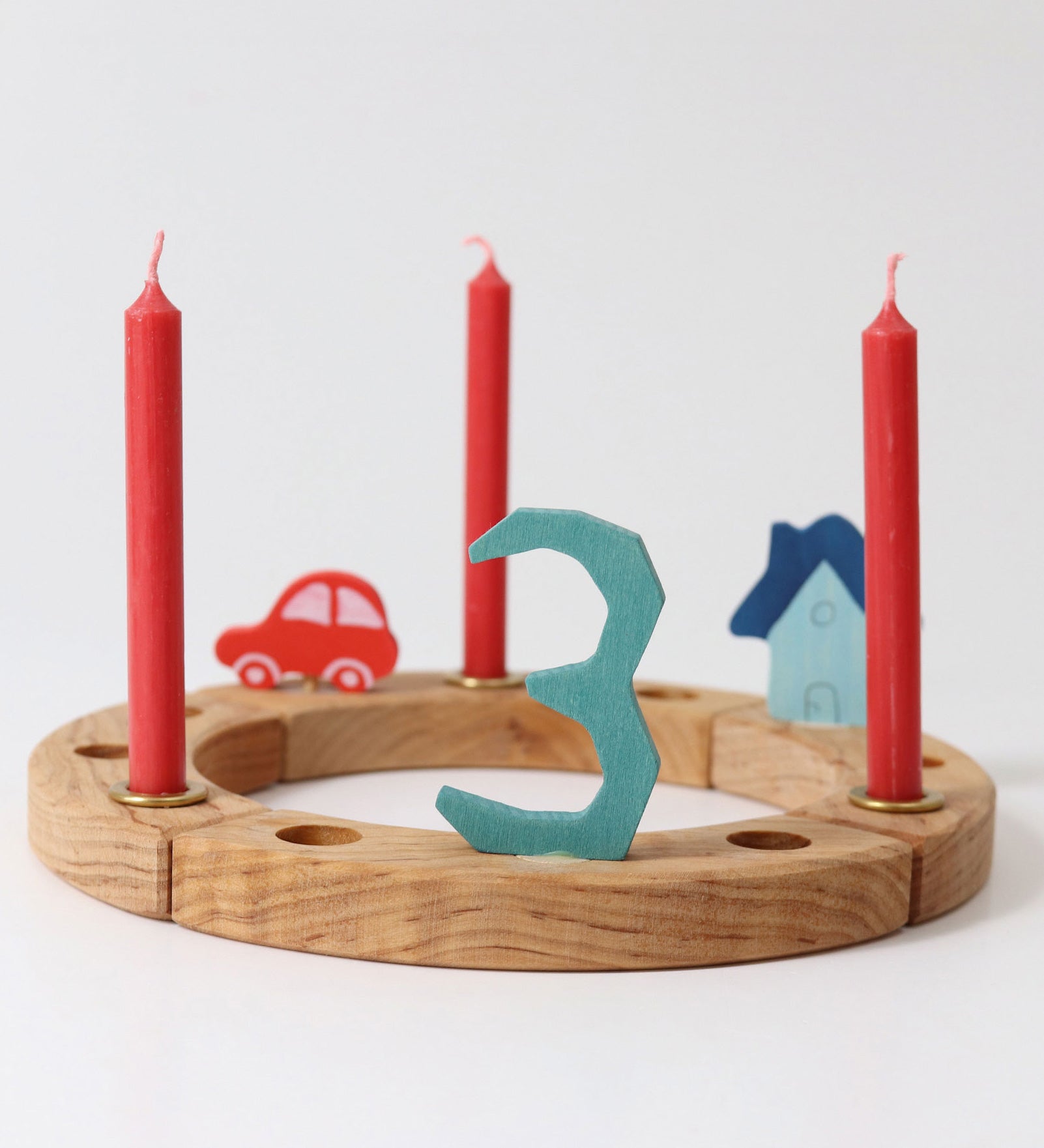 Grimm's Red 10% beeswax candles placed on a natural celebration ring.