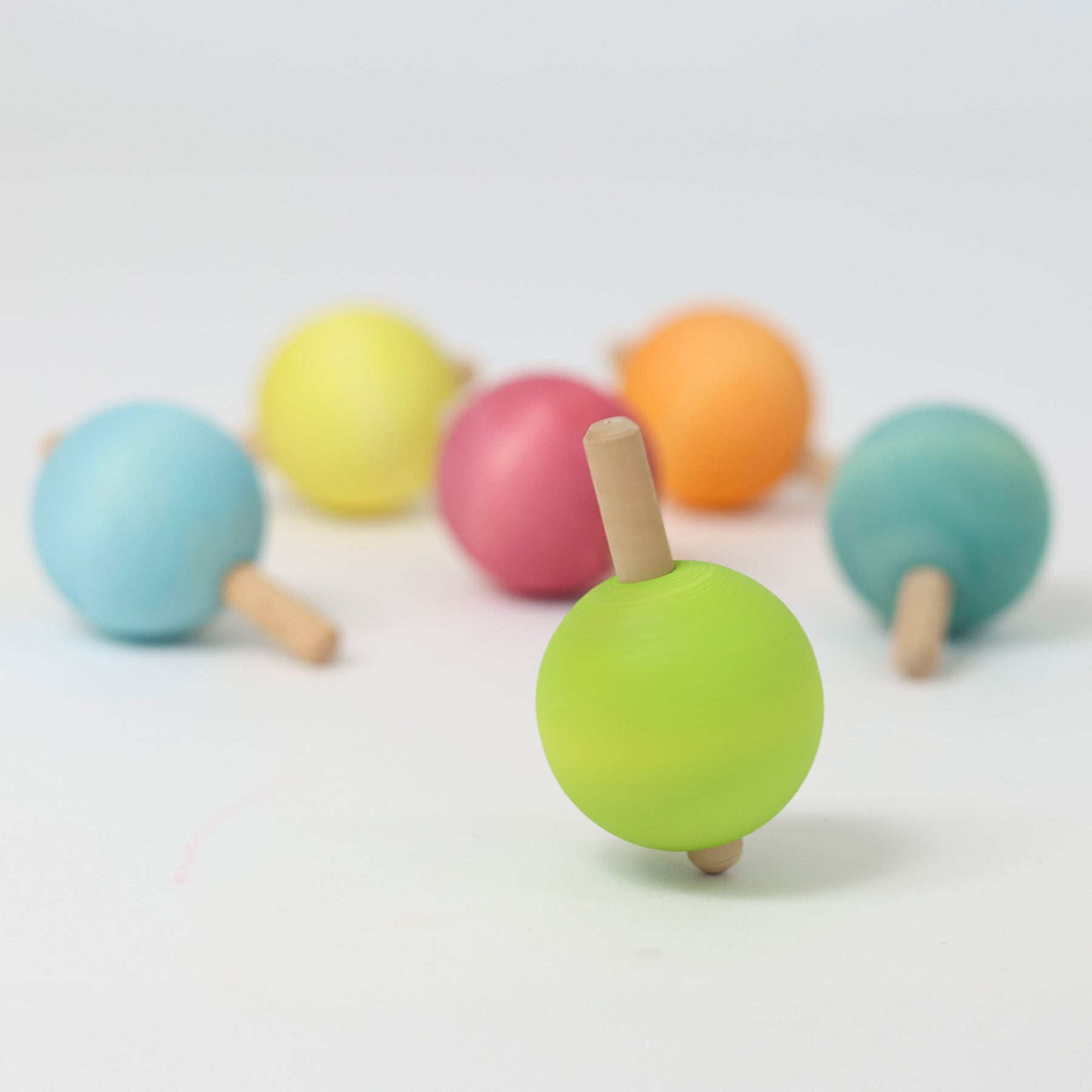 The six pastel rainbow traditional wooden spinning tops from Grimm's