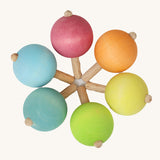 A set of six traditional wooden spinning tops from Grimm's, in pastel rainbow colours and arranged in a circle.