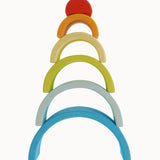 The Grimm's Babi Gwawr Sunrise 6 Piece Rainbow on a plain background. The pieces have been stacked on top of each other with the largest arch at the bottom and the smallest on top.