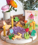 A spring themed display showing the different wooden Grimms decorative figure and candles on the decorative ring
