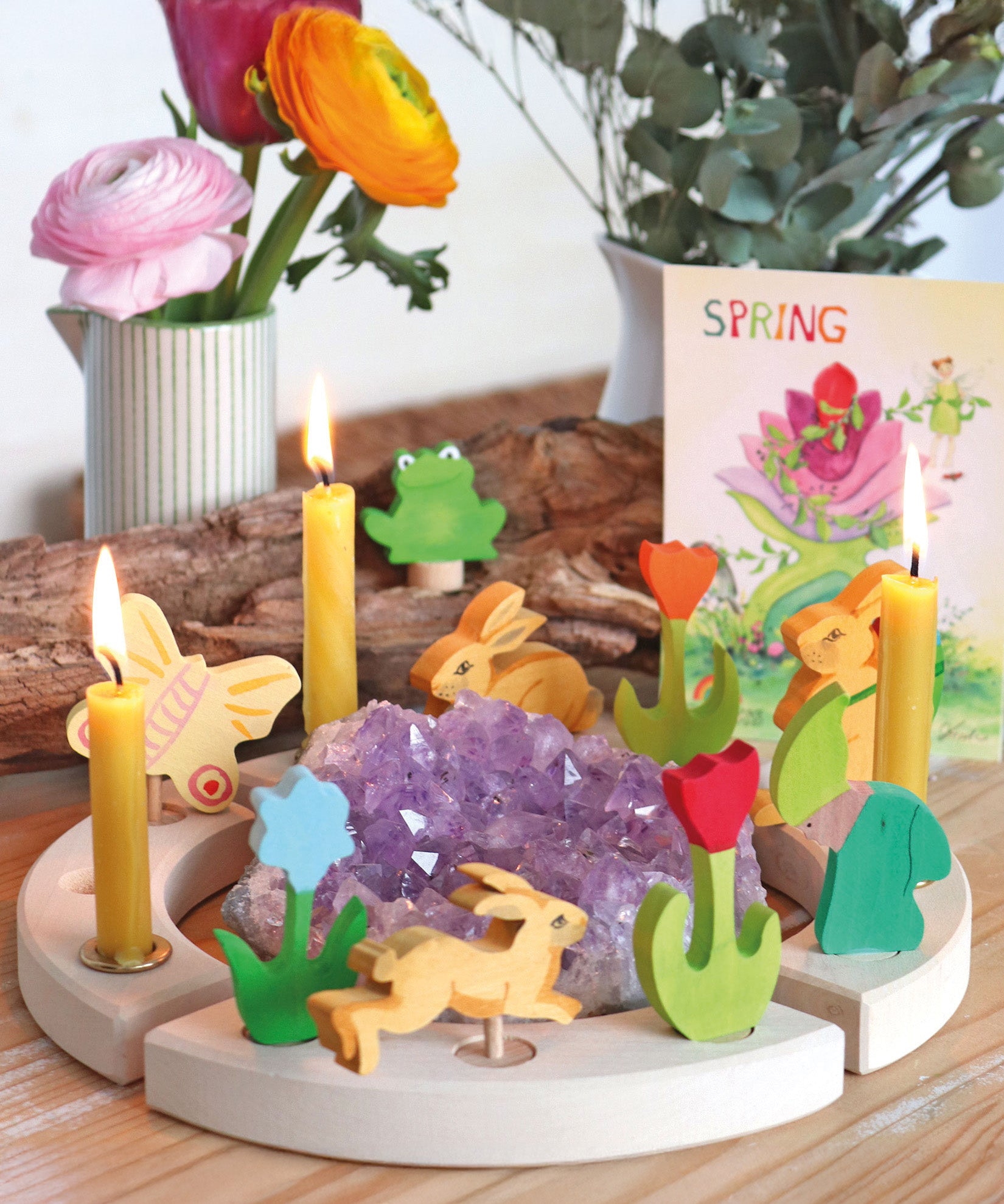 A spring themed display showing the different wooden Grimms decorative figure and candles on the decorative ring