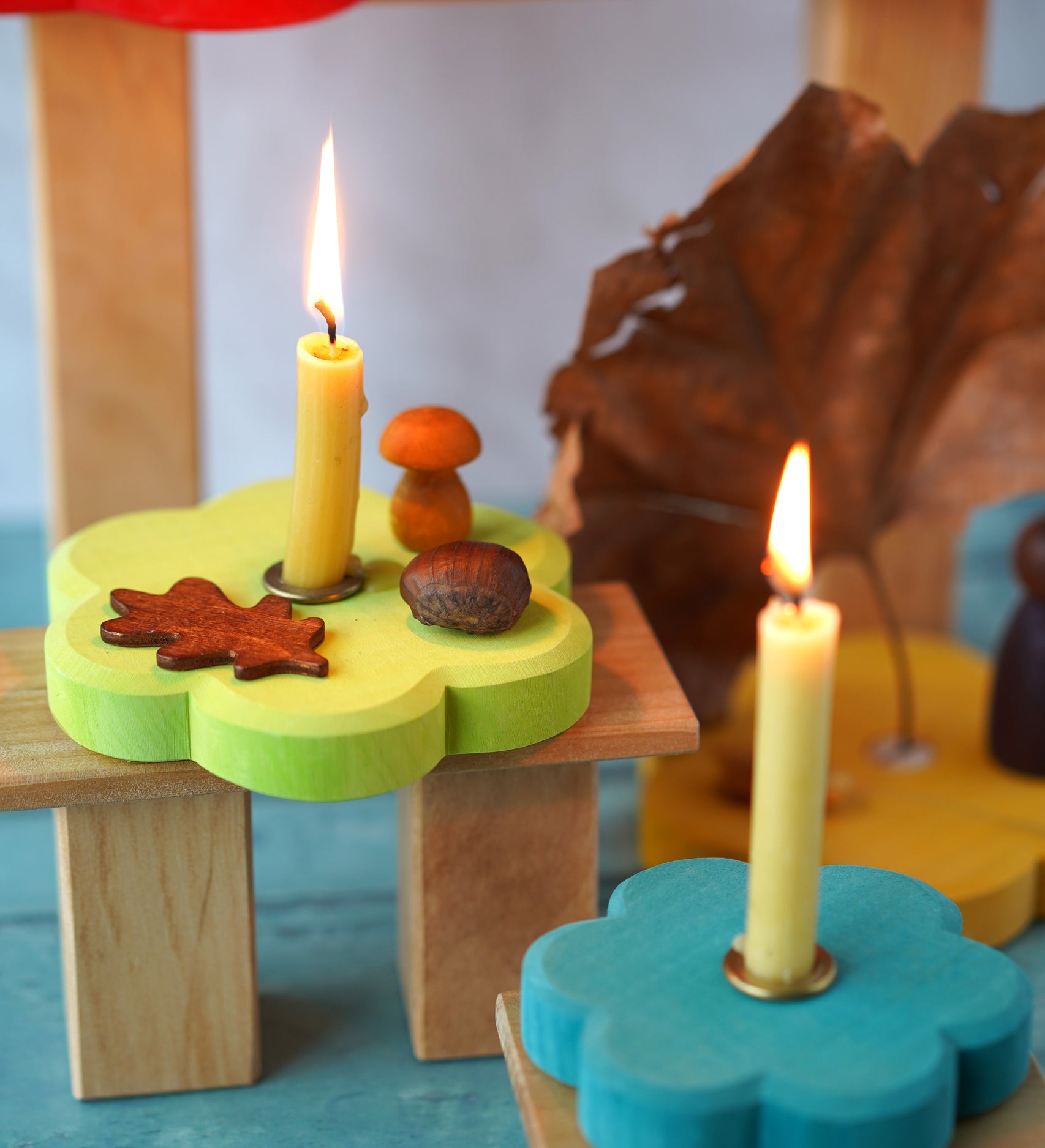 Grimm's Stacking Flowers Tower with two flowers used to hold Grimm's candles with the brass candle holders  as part of an Autumnal seasonal display.