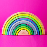 Grimm's 10-Piece Rainbow - Neon Green- on a plain pink background. Front view.