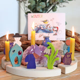 A winter themed display showing the different wooden Grimms decorative figure and candles on the celebration ring