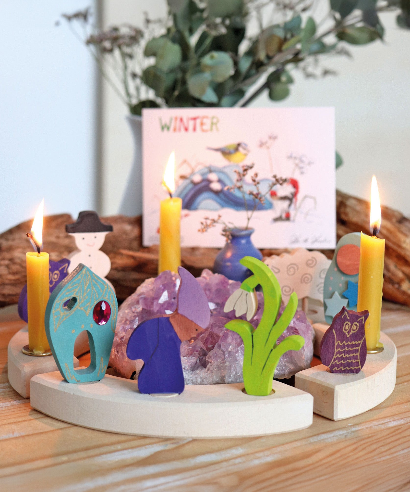 A winter themed display showing the different wooden Grimms decorative figure and candles on the celebration ring