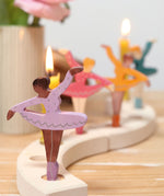 A cosy display showing the different coloured ballerina Grimms wooden decorative figures slotted in the the celebration ring