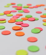 A close up of the Grimms wooden confetti dots. Showing the hand painted neon finish