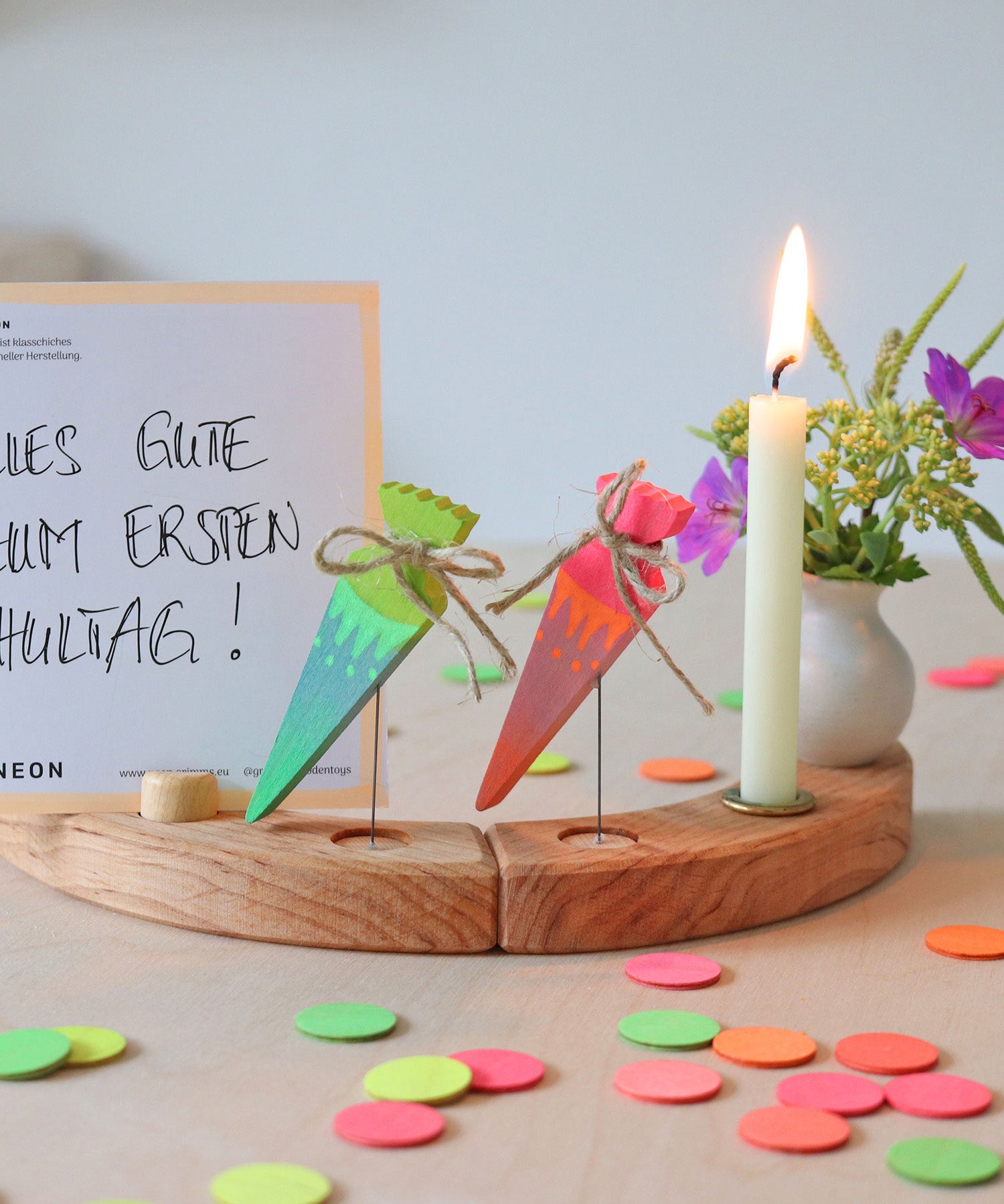 Grimm's Sweet Cone wooden Decorative Figure - Neon Green. The cone sits inside the Celebration ring alongside the Neon Pink Cone and a candle.