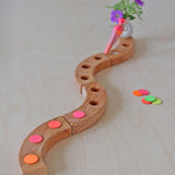 Grimm's Neon Celebration Confetti Dots. The dots sit on top of a celebration ring on a wooden table.