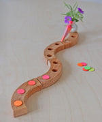 Grimm's Neon Celebration Confetti Dots. The dots sit on top of a celebration ring on a wooden table.