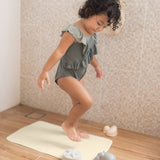 Child stood on the Hevea natural rubber bath mat in a beige shower