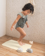 Child stood on the Hevea natural rubber bath mat in a beige shower