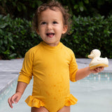 Hevea sand rubber duck held by child near swimming pool