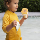 Hevea Upcycled rubber sand duck and sage frog toys being played in the pool by a small child