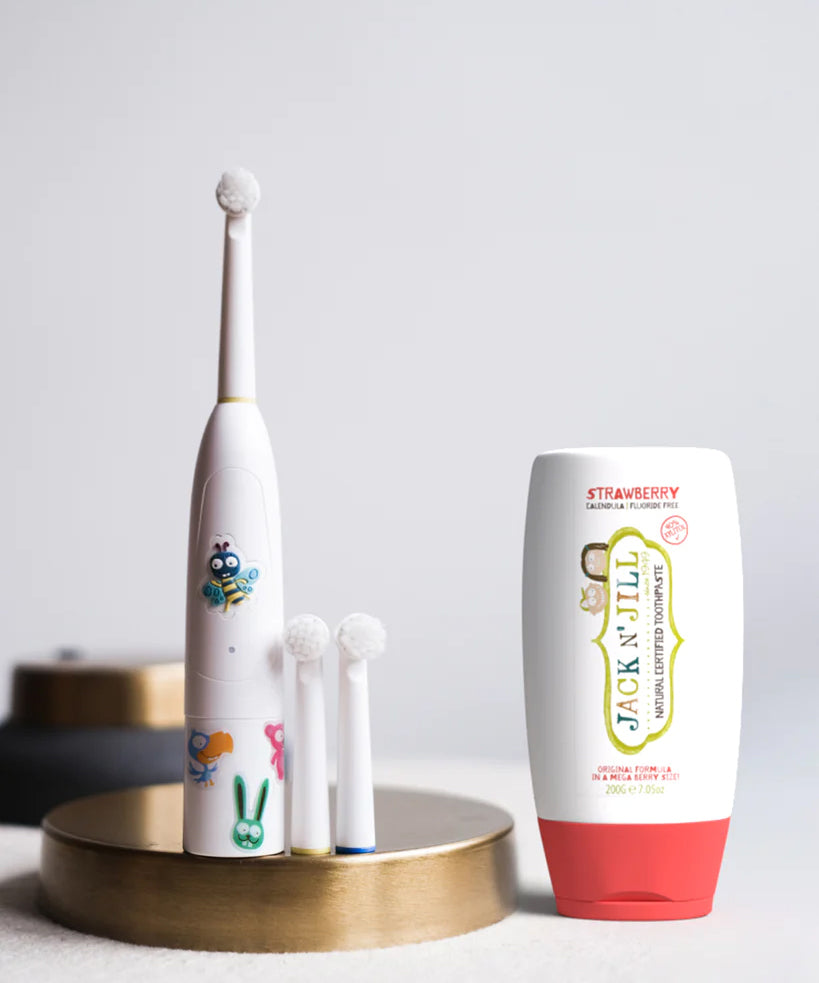 Jack N' Jill Fluoride-Free Strawberry Toothpaste 200g pictured next to buzzy brush toothbrush.