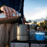 stainless steel reusable bottle with a black loop cap lid on a white background