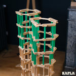 The Kapla 40 Square wooden engineering blocks set - light green planks with natural wood planks to create a tall structure.