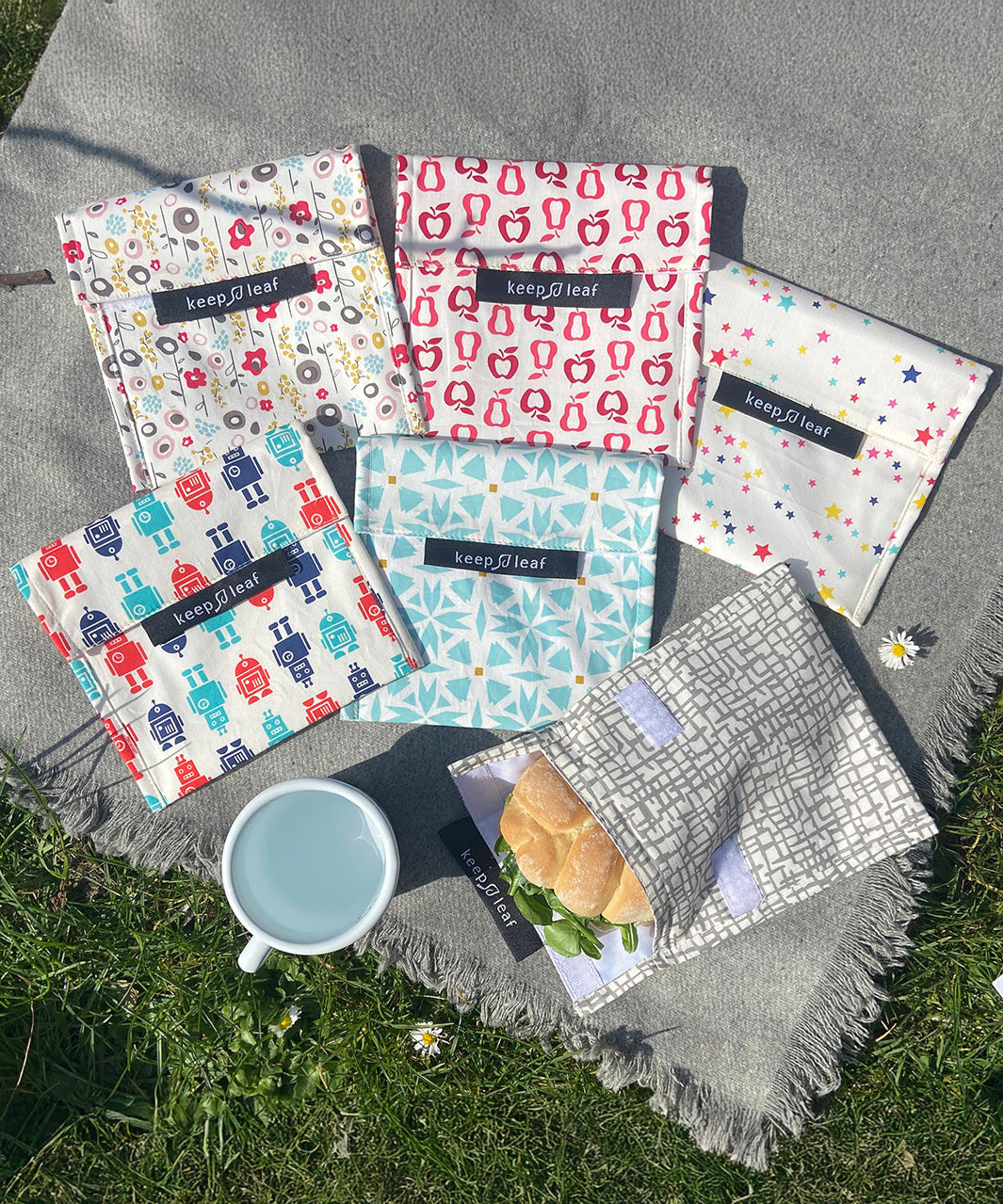 A group of Keep Leaf large baggies outside on a grey blanket showing the mesh, geo, robot, stars, new fruit and bloom designs