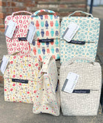 A group of Keep Leaf insulated lunchbags on a concrete step. Features a new fruit, robot, geo, bloom, stars and mesh designs