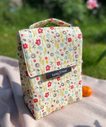Keep Leaf insulated lunchbag in bloom design on a blanket in the garden