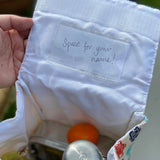 A close up of the pouch on the inside of the lid showing a name tag.