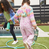Two children playing outdoors, one has a Mountain Scape Kid Kanteen 12oz Insulated Flip Seal Sport Cap Bottle and the other has a Dino Skate print bottle.