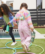 Two children playing outdoors, one has a Mountain Scape Kid Kanteen 12oz Insulated Flip Seal Sport Cap Bottle and the other has a Dino Skate print bottle.