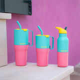 Klean Kanteen turquoise kaleidoscope 16oz, 26oz and 36oz rise insulated stainless steel bottle and tumblers on a stone surface and a purple wall showing the scale and the vibrant pink and turquoise colour way design and handle detail on the tumblers