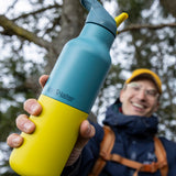 A man holding the Brittany 16oz stainless steel reusable klean kanteen insulated rise bottles showing the colour way design detail
